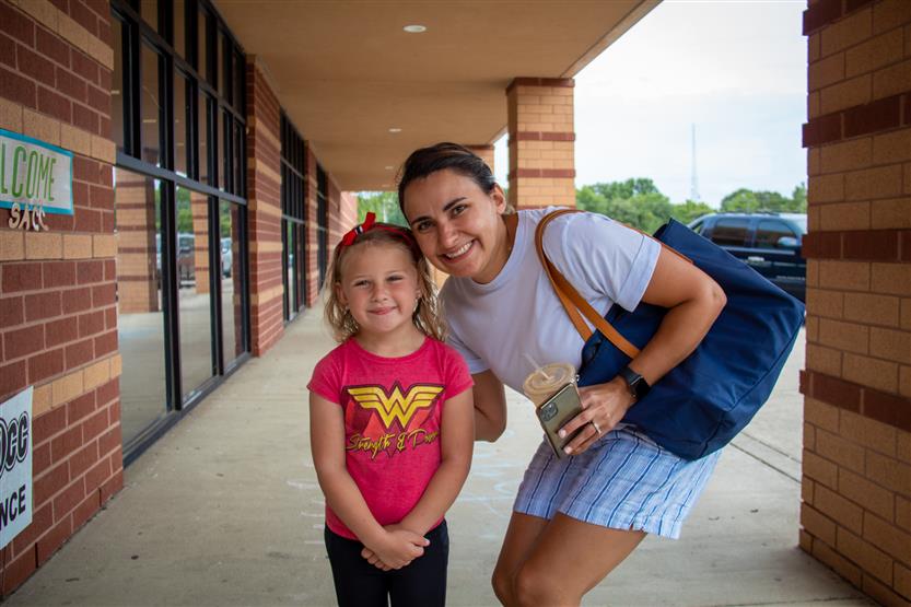 A family smiles on their first day of school